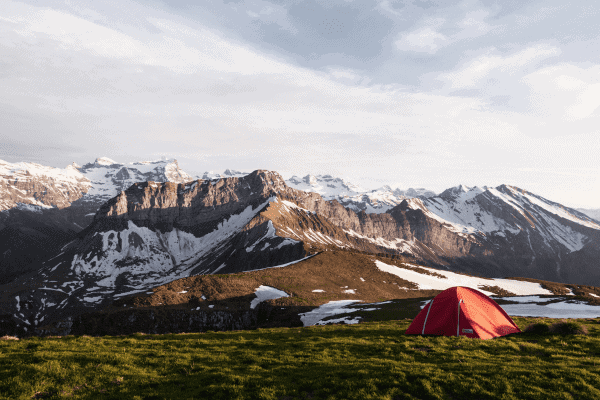 Tent pitched in front of a mountain backdrop.