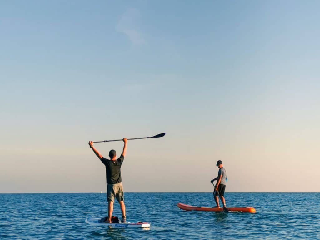 2 men paddle boarding on the open sea