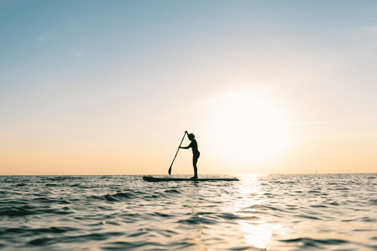 Woman paddling on the open sea