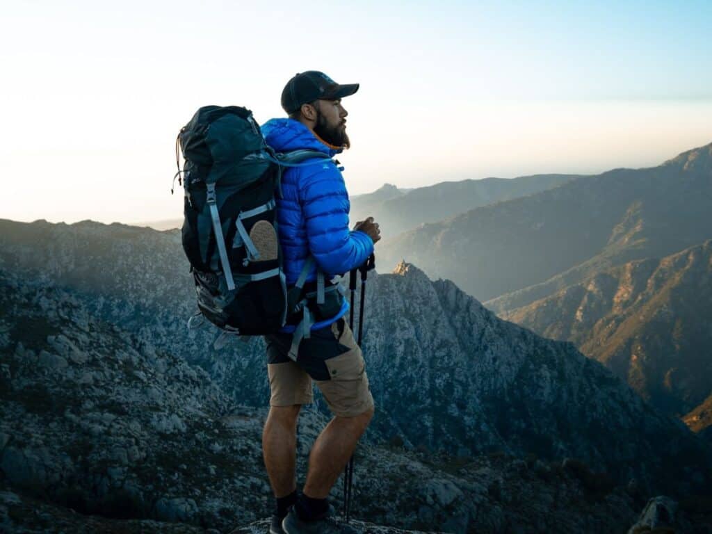 Man wear his backpack whilst hiking