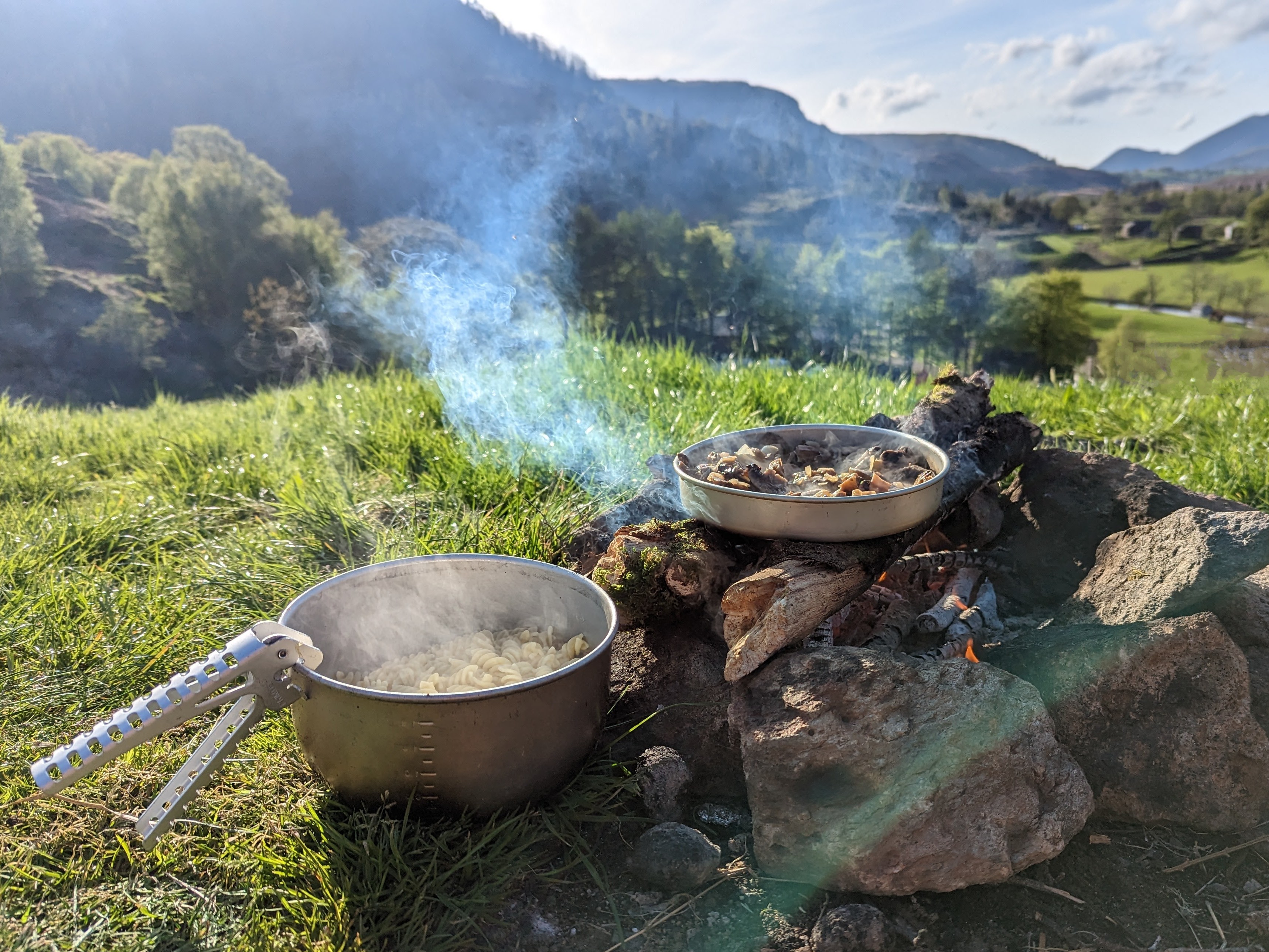 Cooking mushrooms and pasta on a campfire