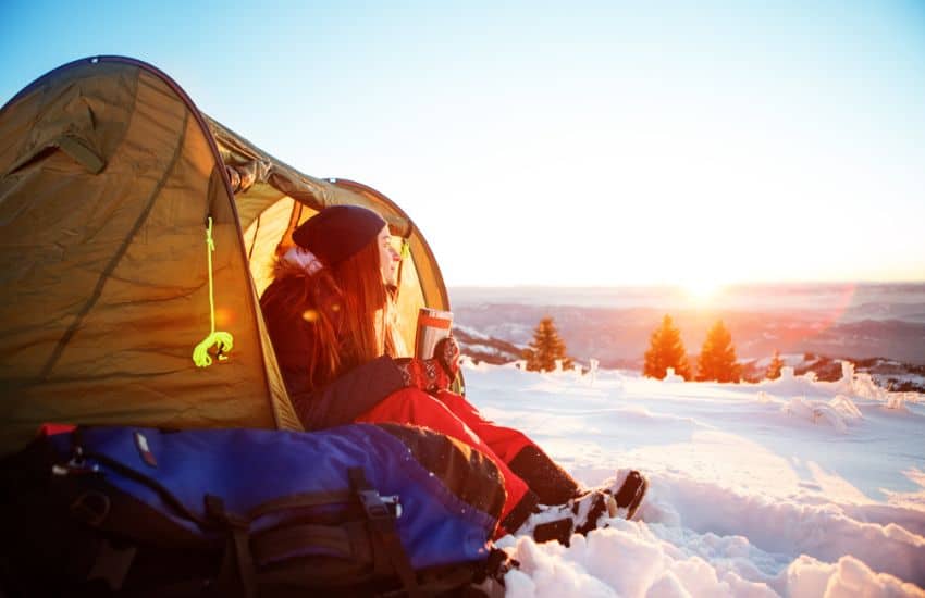 Girl in her tent surrounded by snow